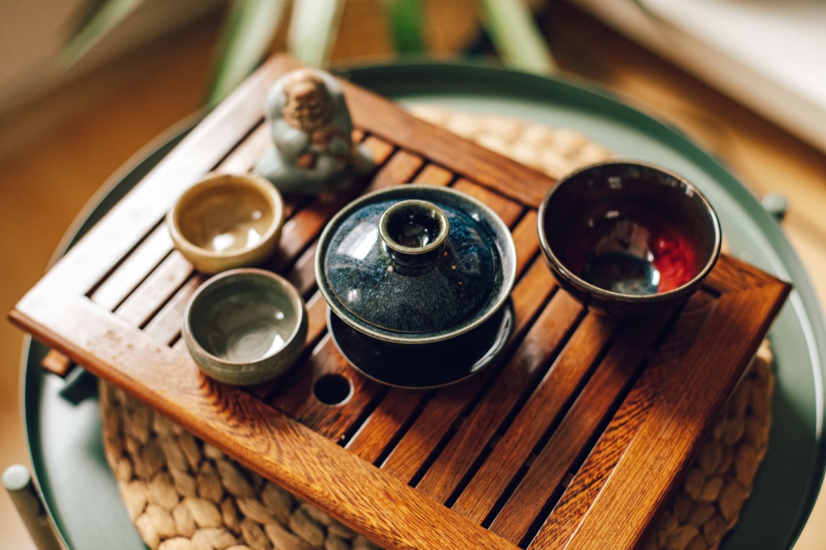 Vintage keychain and ceramic tea cup in a wooden tray