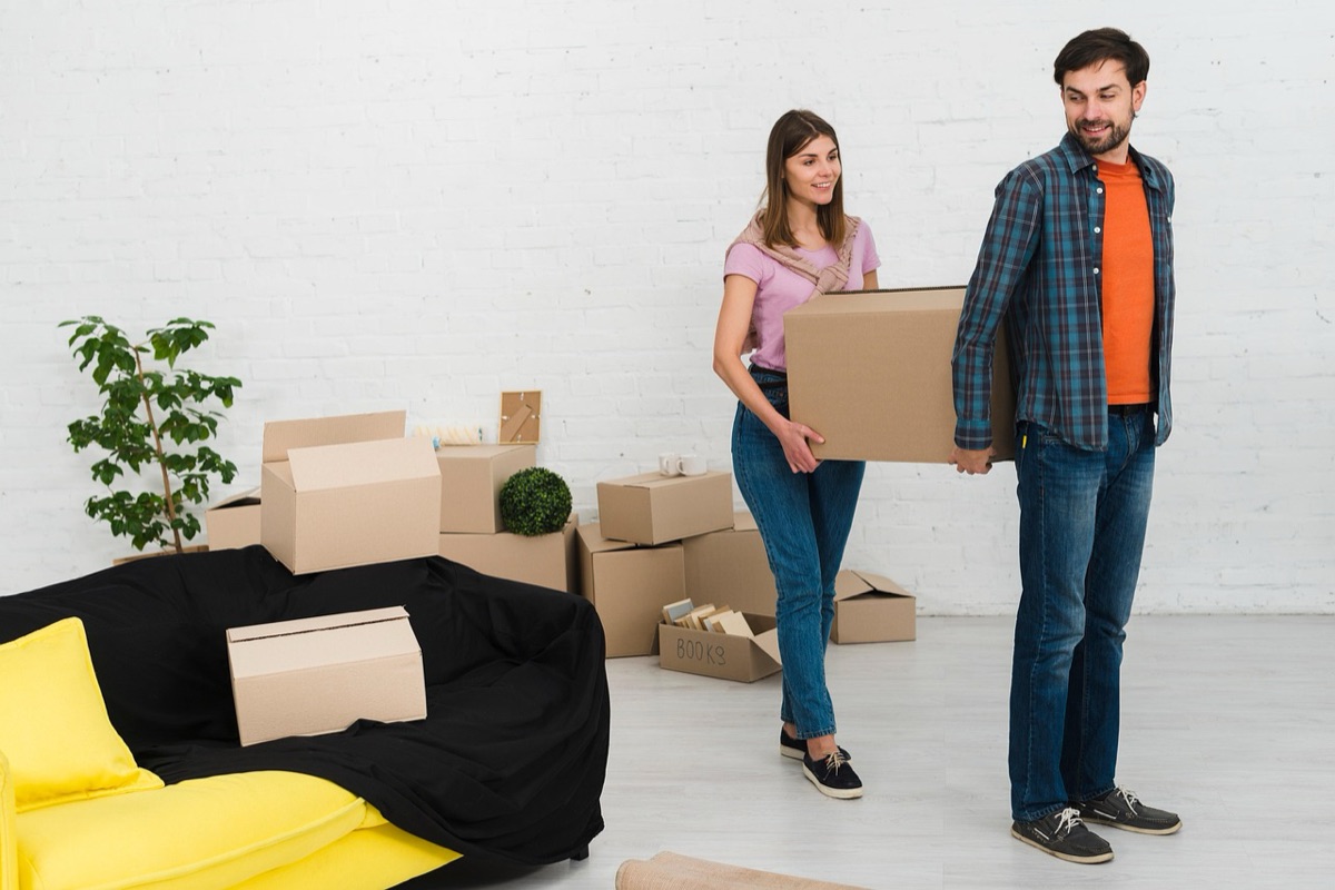 person organizing moving boxes in living room for move efficiency