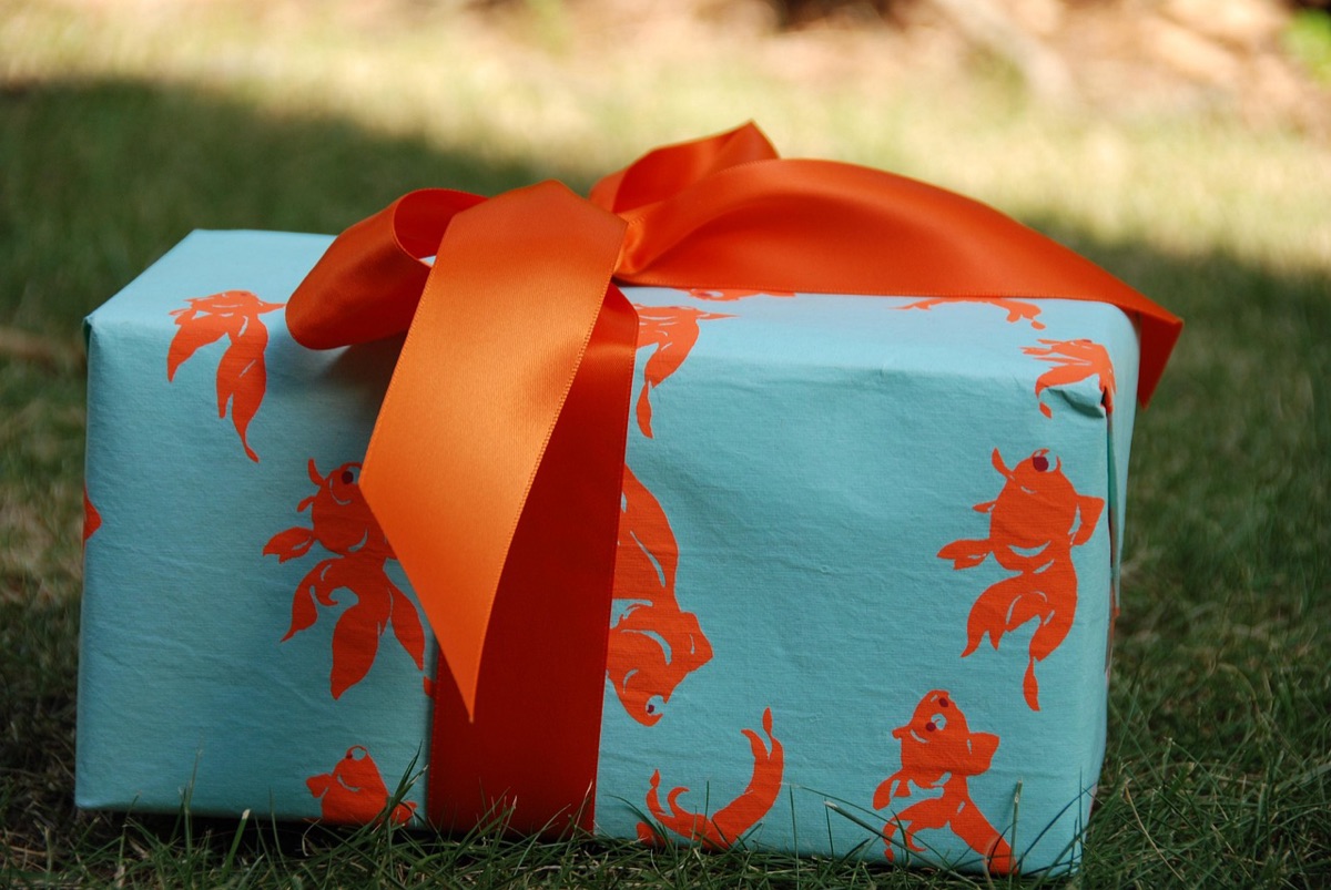 Ehepaar hält verpacktes Geschenk in dunklem Zimmer